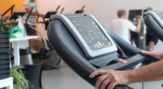 Man oefent op loopband tijdens cardiologische revalidatie