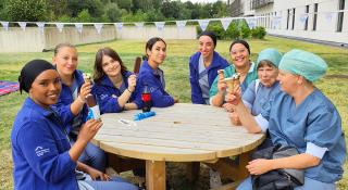 Medewerkers uit het ziekenhuis zitten rond een picknicktafel om gekregen ijsjes te eten